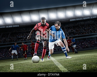 Les joueurs de soccer ball chasse sur terrain Banque D'Images