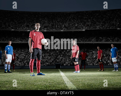 Soccer player holding ball on field Banque D'Images