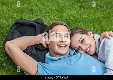 Portrait of young couple lying on grass Banque D'Images