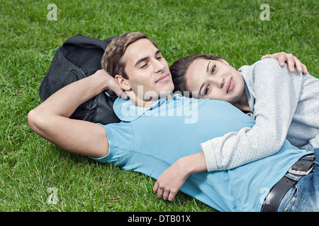 Jeune couple lying on grass Banque D'Images