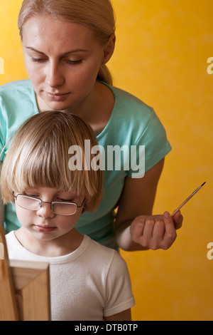 Mère et fils painting on easel Banque D'Images