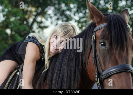 Young woman lying on horse Banque D'Images