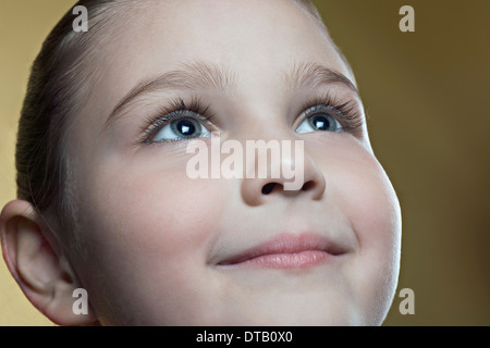 Girl looking up and smiling, close-up Banque D'Images