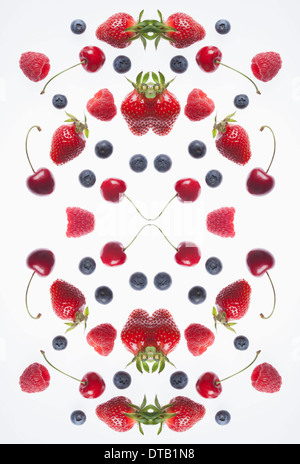 Un composite numérique d'images en miroir d'un arrangement de divers petits fruits et de cerise Banque D'Images