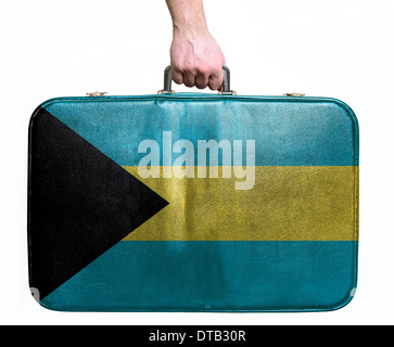 Tourist hand holding vintage sac de voyage en cuir avec le drapeau des Bahamas Banque D'Images