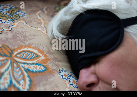 Femme Olderly dormir avec un masque d'oeil Banque D'Images