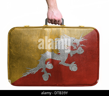 Tourist hand holding vintage sac de voyage en cuir avec drapeau du Bhoutan Banque D'Images