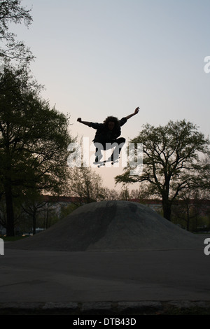 Silhouette d'un skateur professionnel sautant à travers le ciel. Super pour un sport extrême. Banque D'Images