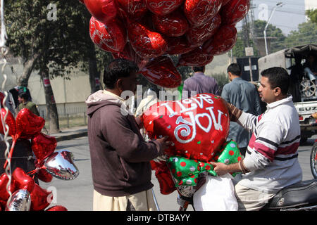 Lahore, Pakistan. Feb 14, 2014. Un homme achète des ballons en forme de cœur sur la Saint-Valentin à Lahore, au Pakistan, le 14 février 2014. La Saint-Valentin est de plus en plus populaire parmi les jeunes Pakistanais, dont beaucoup ont pris les coutumes de donner les cartes, des chocolats et des cadeaux à leurs fiancées pour célébrer l'occasion. Credit : Jamil Ahmed/Xinhua/Alamy Live News Banque D'Images