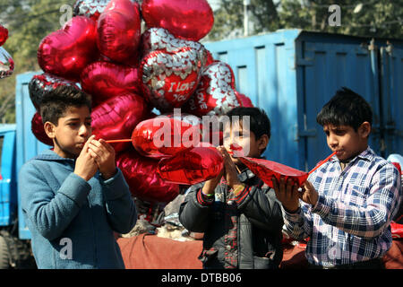 Lahore, Pakistan. Feb 14, 2014. Les garçons vendent des ballons en forme de cœur sur la Saint-Valentin à Lahore, au Pakistan, le 14 février 2014. La Saint-Valentin est de plus en plus populaire parmi les jeunes Pakistanais, dont beaucoup ont pris les coutumes de donner les cartes, des chocolats et des cadeaux à leurs fiancées pour célébrer l'occasion. Credit : Jamil Ahmed/Xinhua/Alamy Live News Banque D'Images