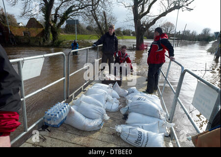 Burrowbridge, UK. Feb 13, 2014. Les bénévoles des sacs de ferry sur un ponton flottant à Burrowbridge Somerset Levels. Paul Glendell Crédit/Alamy Live News Banque D'Images