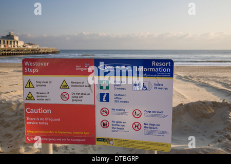 Signaux d'avertissement et d'information sur la plage à Westover, Bournemouth, avec l'embarcadère et la mer en arrière-plan. Banque D'Images