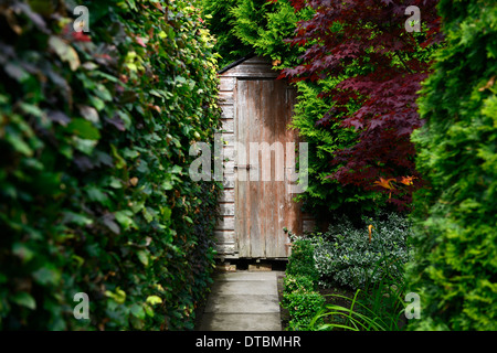 Abri de jardin couvercle porte caché cacher isolée couverts de végétation schéma de plantation haie hêtre sentier chemin de pierre jardin Banque D'Images