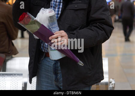 London UK. 14 février 2014. Un homme avec une rose rouge à la gare de Paddington, London à acheter des fleurs sur St Valentines Day qui est associé avec l'amour romantique Crédit : amer ghazzal/Alamy Live News Banque D'Images