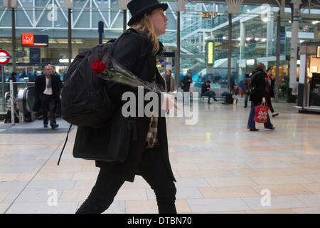 London UK. 14 février 2014. Un homme porte une rose rouge à la gare de Paddington, London à acheter des fleurs sur St Valentines Day qui est associé avec l'amour romantique Crédit : amer ghazzal/Alamy Live News Banque D'Images