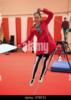 Femme, en robe rouge, effectuant un slackline solo libre à Blackpool, Lancashire, Royaume-Uni février 2014. NoFit State Circus est une société de cirque contemporaine basée à Cardiff, pays de Galles. Une troupe d'acrobates au festival annuel de variété de Blackpool. Le festival de dix jours des actes qui est Showzam voit les célèbres monuments de Blackpool envahi par les marcheurs en corde raide, Banque D'Images