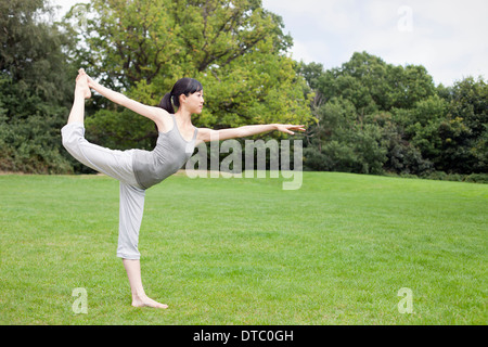 Jeune femme dans la pratique du yoga parc roi posture du danseur Banque D'Images