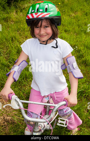 Heureux, fier, souriant fille de cinq ans d'apprendre à monter un vélo. Banque D'Images