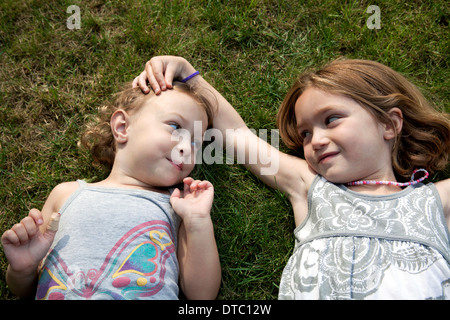 Portrait de deux jeunes sœurs lying on grass Banque D'Images