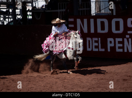 Un escaramuza galope sur son cheval avant la compétition dans un Escaramuza dans le Lienzo Charros el Penon, Mexico City Banque D'Images