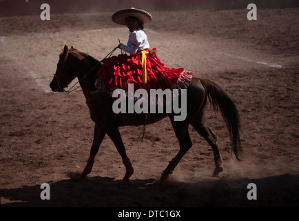 Un escaramuza rides son cheval avant la compétition dans un Escaramuza dans le Lienzo Charros el Penon, Mexico City Banque D'Images