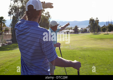 Deux golfeurs masculins et à la direction de pointage Banque D'Images
