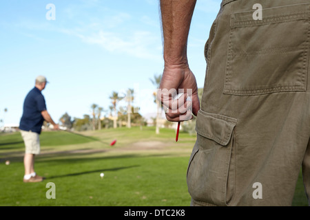 Deux golfeurs masculins en tenant tourné sur vert Banque D'Images