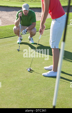 Jeune femme queue balle de golf avec un instructeur Banque D'Images