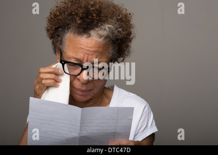 Studio portrait of senior woman reading triste une lettre Banque D'Images