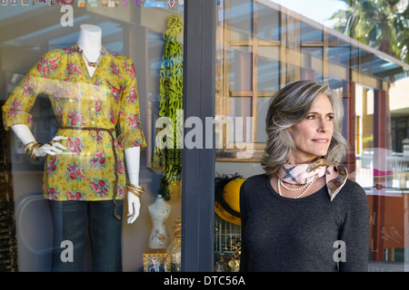 Femme debout à l'extérieur fenêtre boutique Banque D'Images