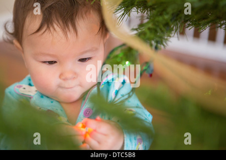 Baby Girl touching fairy lights Banque D'Images