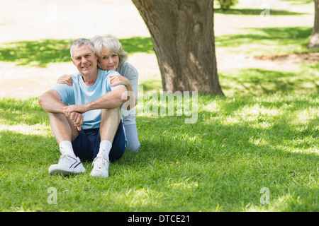 Young couple sitting on grass at park Banque D'Images