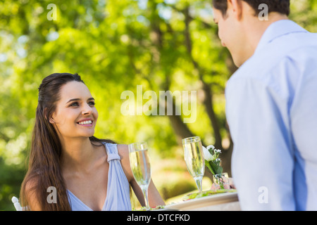 Couple avec des flûtes à champagne assis à une piscine cafÃ© Banque D'Images