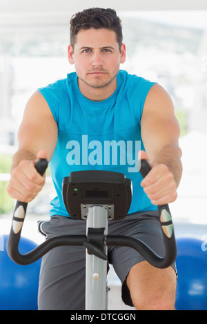 Young man working out at spinning class Banque D'Images