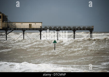 Pays de Galles Aberystwyth UK, samedi 15 Fen 2014 rafales de vent jusqu'à 70 mph drive énormes vagues battant contre le mur de la mer et de la promenade à Aberystwyth, sur la côte ouest du pays de Galles de l'UK à marée haute première chose ce matin. Après des mois de coups de vent violents et puissants raz de marée, des vents forts d'aujourd'hui sont appelées à être la dernière sur la séquence en cours de tempêtes. Le temps se calme, bien que la pluie, est prévue pour les prochains jours. Credit : Keith morris/Alamy Live News Banque D'Images