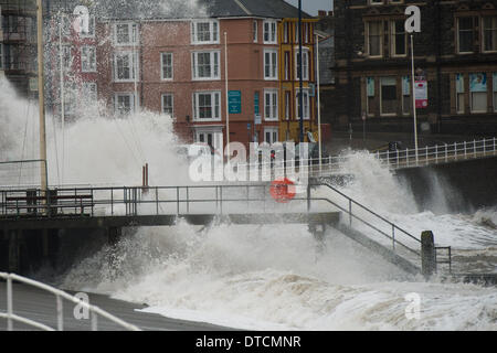 Pays de Galles Aberystwyth UK, samedi 15 Fen 2014 rafales de vent jusqu'à 70 mph drive énormes vagues battant contre le mur de la mer et de la promenade à Aberystwyth, sur la côte ouest du pays de Galles de l'UK à marée haute première chose ce matin. Après des mois de coups de vent violents et puissants raz de marée, des vents forts d'aujourd'hui sont appelées à être la dernière sur la séquence en cours de tempêtes. Le temps se calme, bien que la pluie, est prévue pour les prochains jours. Credit : Keith morris/Alamy Live News Banque D'Images