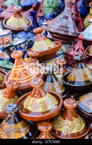 Petite poterie émaillée aux couleurs vives, tajines empilées sur l'affichage dans un marché marocain. Banque D'Images