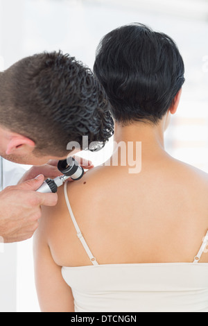 Dermatologist examining mole on woman Banque D'Images