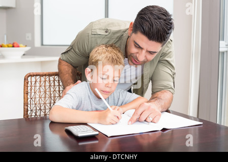 Happy father helping son avec devoirs de mathématiques à table Banque D'Images