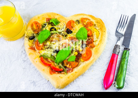 Pizza en forme de cœur sur un fond blanc Banque D'Images