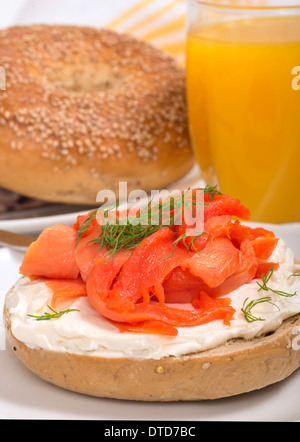 De délicieux bagels fraîchement préparés avec du fromage à la crème, saumon fumé, aneth et servi avec du jus d'orange Banque D'Images