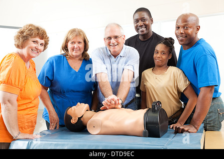 Cours pour adultes sur la RCR et premiers soins. Les élèves et l'enseignant avec mannequin. Banque D'Images