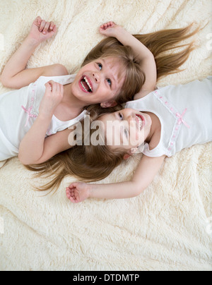 Happy little girls lying on retour vue d'en haut Banque D'Images