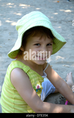 5-year-old girl laughing in green hat Banque D'Images