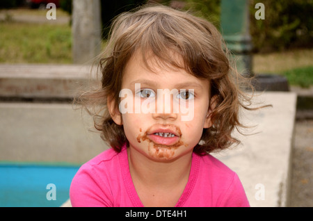 4 ans, fille, tachée de lécher la crème glacée Banque D'Images