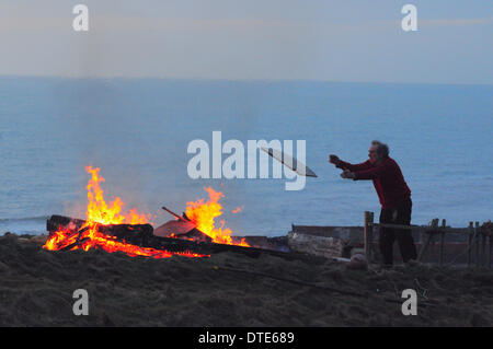 Urrugne, East Sussex, UK. 16 février 2014. Couple quitter leur maison en raison de la tempête. Urrugne, East Sussex, UK. 16 février 2014. M. Oaten burns et meubles de l'ancien abri de jardin. Maison de vacances pour 5 ans avec un autre 5 tempête attendue, mais l'érosion a été si rapide récemment, la famille a décidé de partir. Partie de la fin cottage se trouve à seulement 1 mètres du bord. Crédit : David Burr/Alamy Live News Banque D'Images