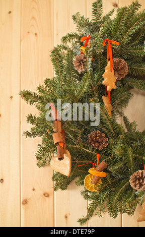 Style vintage une couronne de Noël avec des biscuits en pain d'épices traditionnels décorations naturelles sur un fond en bois vertical aux États-Unis haute résolution Banque D'Images