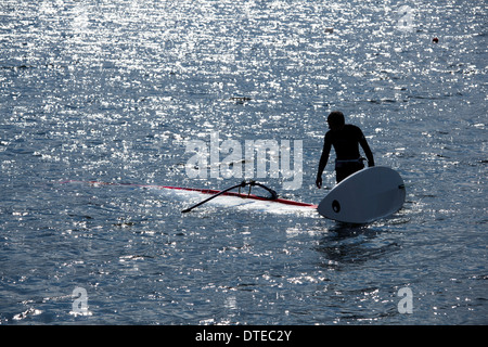 Kite-surfer se trouve dans l'eau, tenant sa planche de surf Banque D'Images