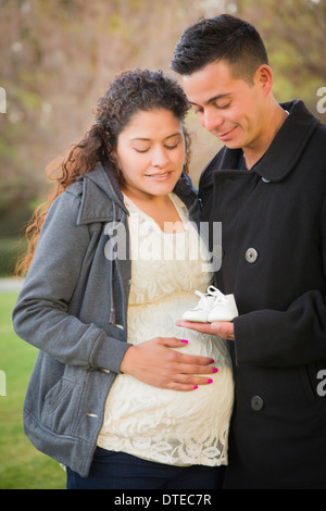 Happy young pregnant woman Holding Baby Shoes en extérieur dans le parc. Banque D'Images