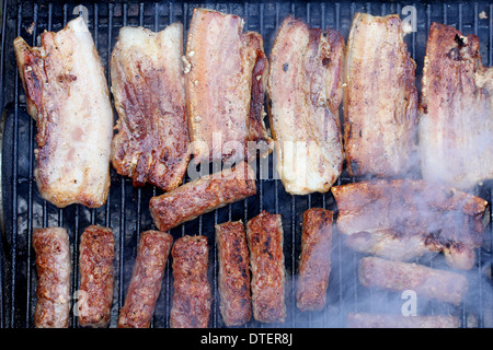 Bacon frit et les brochettes sur le grill Banque D'Images